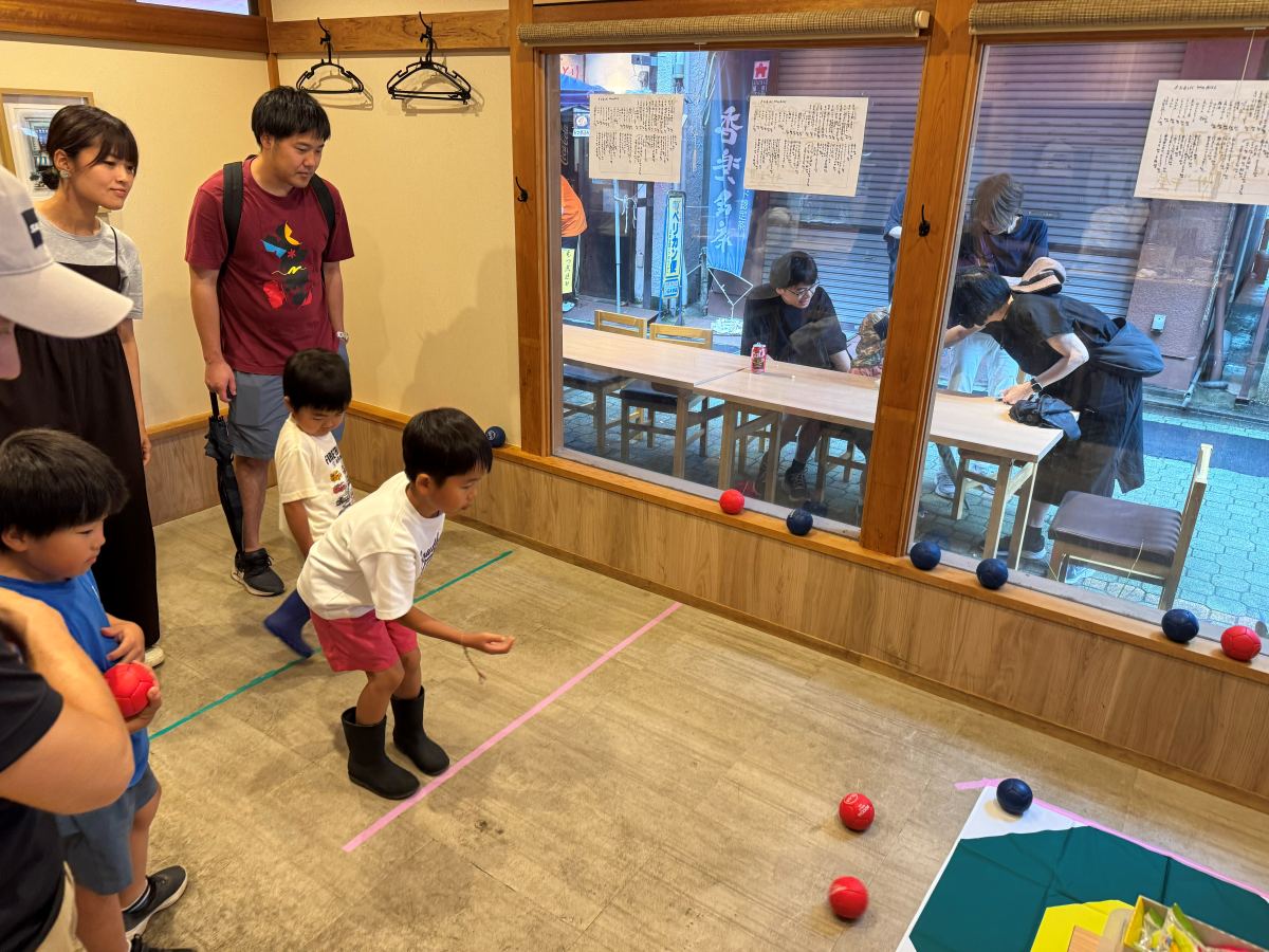 ザキ屋の店内で、子どもがボッチャのボールを投げている様子